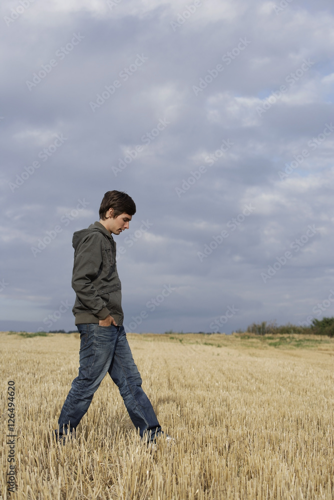 Profile of young man walking in wheat field Profile of young man walking in wheat field