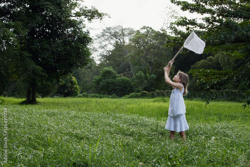 young girl chasing butterflies with net