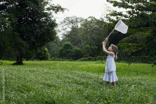 Obraz na płótnie young girl chasing butterflies with net w salonie