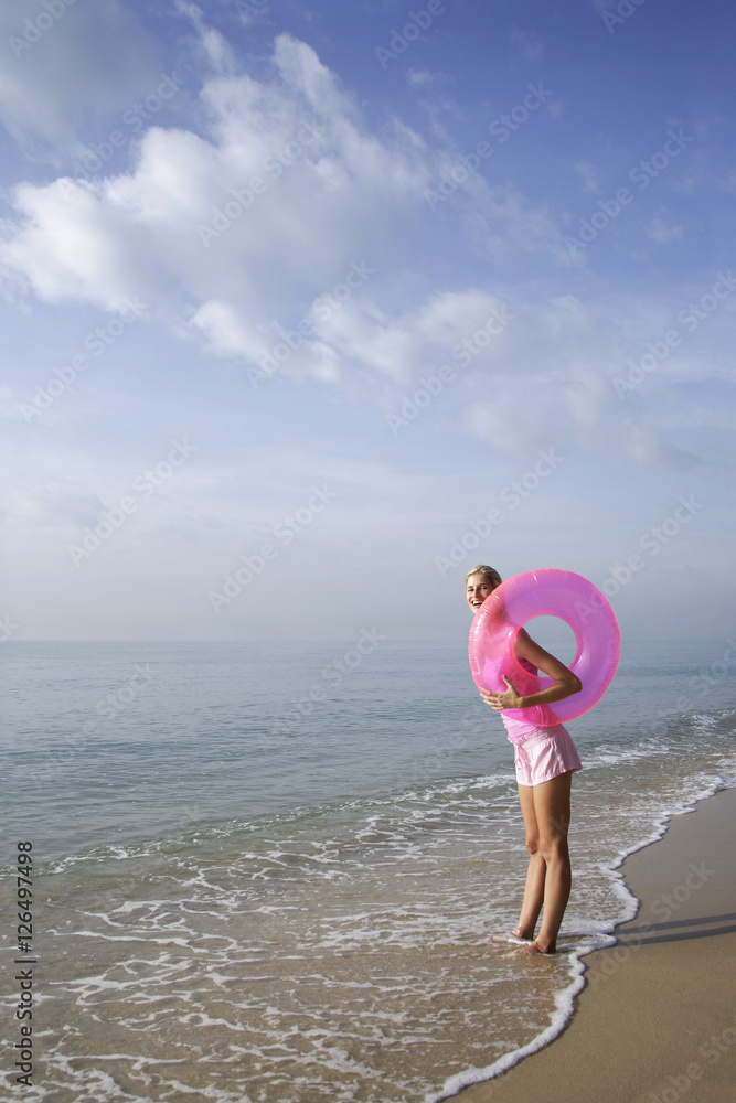 woman at beach with pink tube