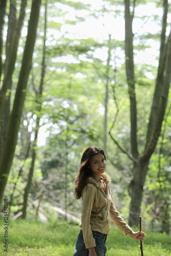 young woman walking among trees