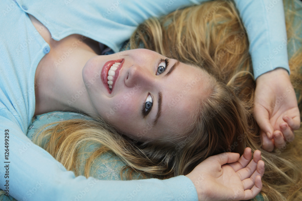 Head shot of young blonde woman laying down smiling Head shot of young blonde woman laying down smiling