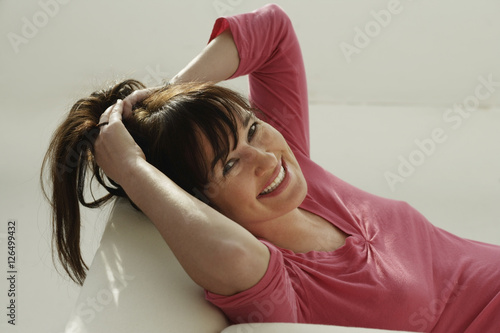 Woman smiling at camera holding her hair.