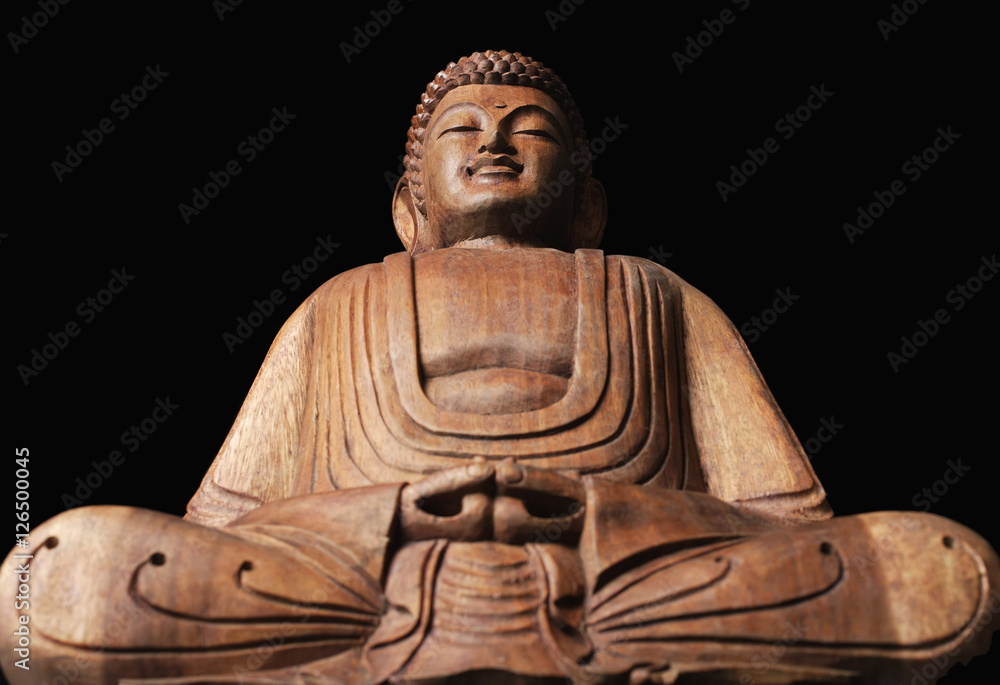 Closeup of sitting wooden Buddha statue.