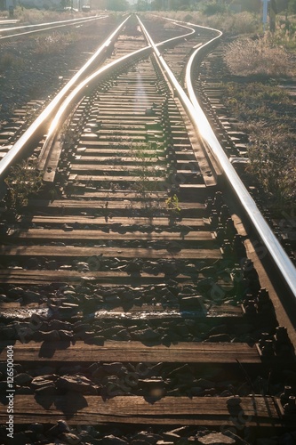 Fototapeta Naklejka Na Ścianę i Meble -  Railway tracks with girder and gravel against sunshine. Vertical photo