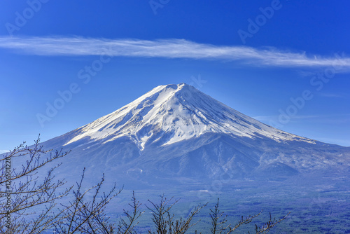 Stunning view of Fuji mountain taken from Kawaguchiko mt's scenic point, in clear blue sky with haze and smoke effect at the bottom of mountain.