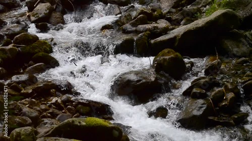 Mountain stream with large dark stones. Water pondin the dark wet large stones closeup. Relaxing natural background sound, loop, meditation. Pond in a forest in Carpathians, Ukraine. photo