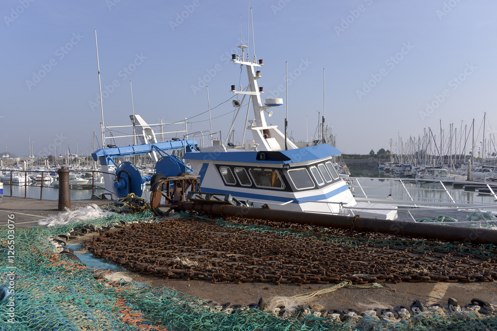 Fishing boat and fishing net in the port of Saint-Vaast-la-Hougue in France