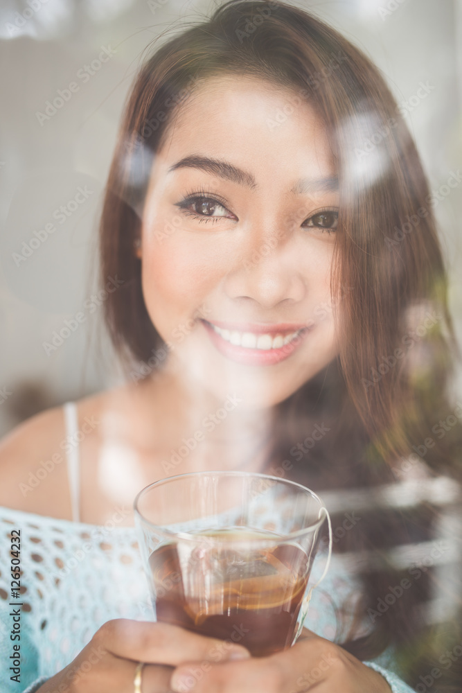 Portrait of a gorgeous young asian woman relaxing with cup of ho Portrait of a gorgeous young asian woman relaxing with cup of ho