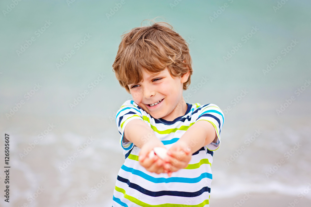 Little kid boy having fun with collecting shells Little kid boy having fun with collecting shells