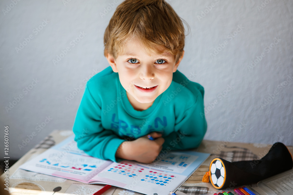 Happy school kid boy at home making homework Happy school kid boy at home making homework