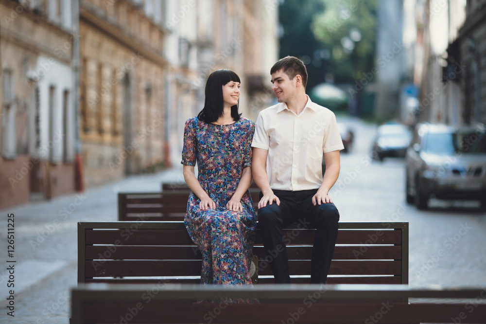 Fototapeta premium Sweet couple is sitting on the wooden bench