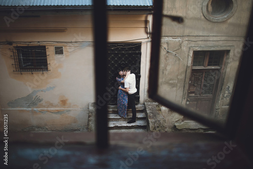 Man is kissing his woman next to the door © andriychuk