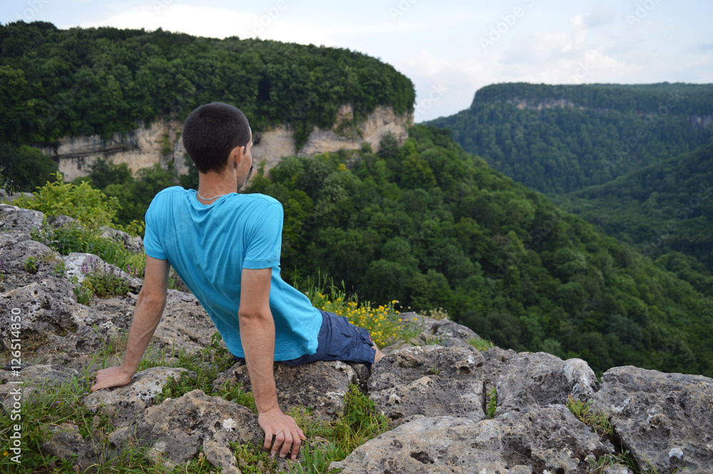 Naklejka premium Tourist looking at mountains near the ruins