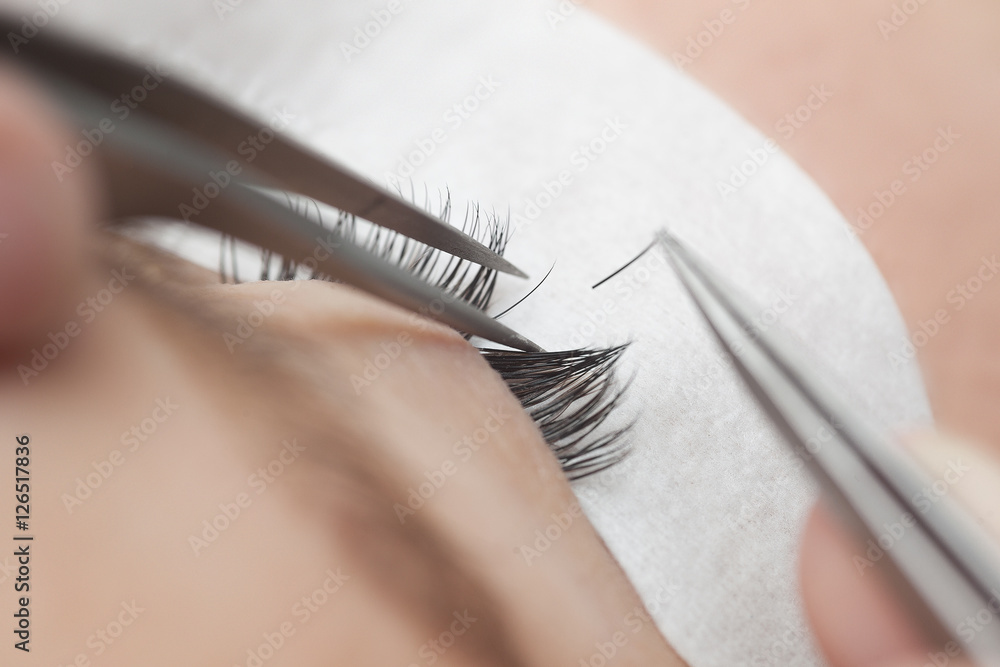 Traditional eyelash extensions. Selective focus. Toned. Makeup close-up. - obrazy, fototapety, plakaty 