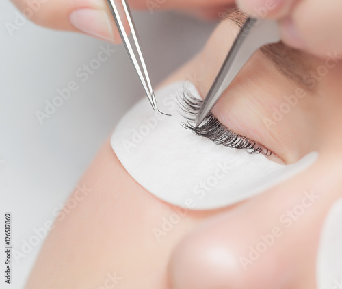 Traditional eyelash extensions. Selective focus. Toned. Makeup close-up.