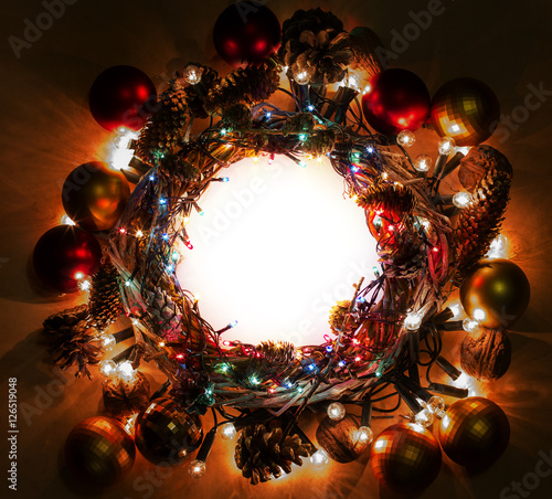 Winter holidays template card with copyspace on dark evening light radial gradient background. Wreath and garlands of colored light bulbs. Concept frame for shops label circle place for best price.