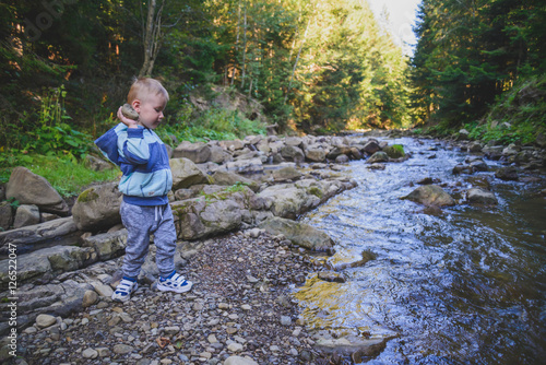 Kid throws rocks to a river