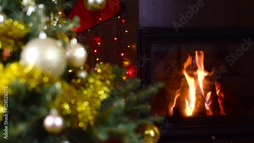 decorated christmas tree with lights in front of fireplace