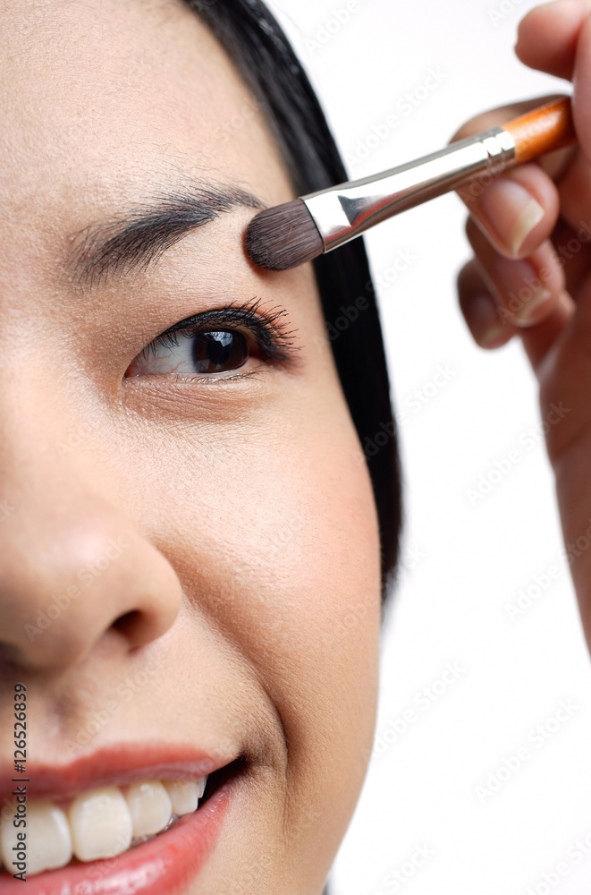 Woman applying eyeshadow, close-up