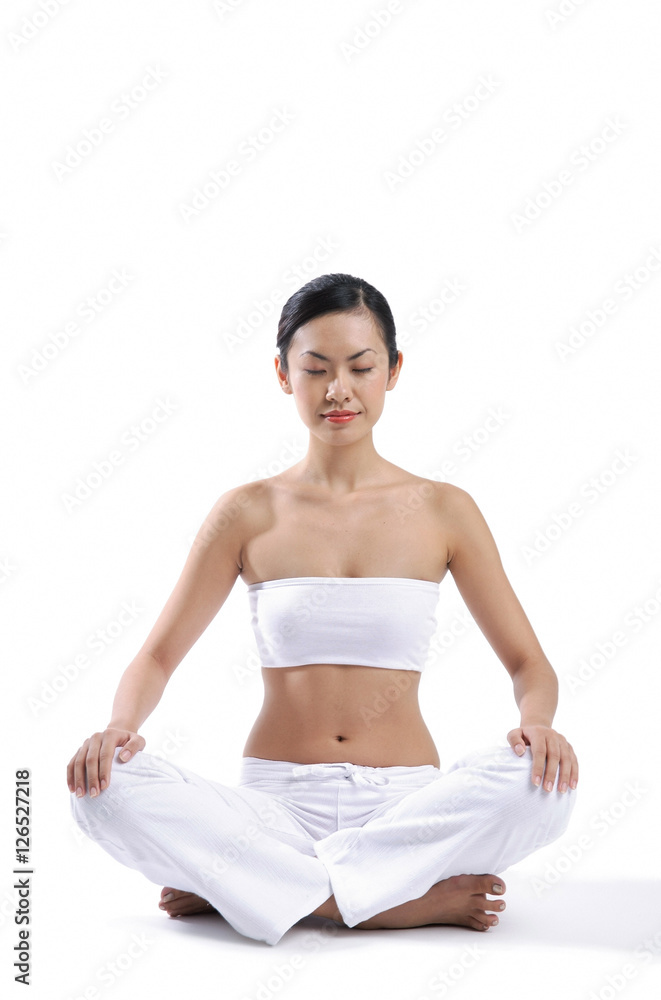 Woman sitting on floor, legs crossed, eyes closed Woman sitting on floor, legs crossed, eyes closed