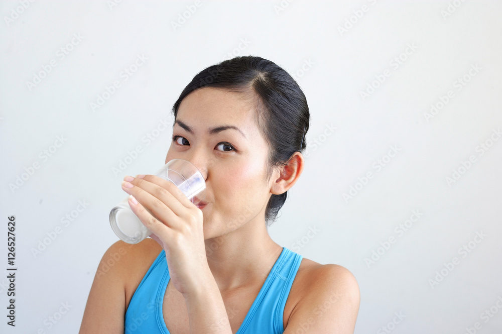 Woman drinking glass of milk, looking at camera Woman drinking glass of milk, looking at camera