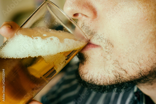 Hombre joven bebiendo un vaso de cerveza  photo