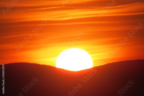 Smooth orange sunset behind two mountains in Levis, Quebec, Canada.