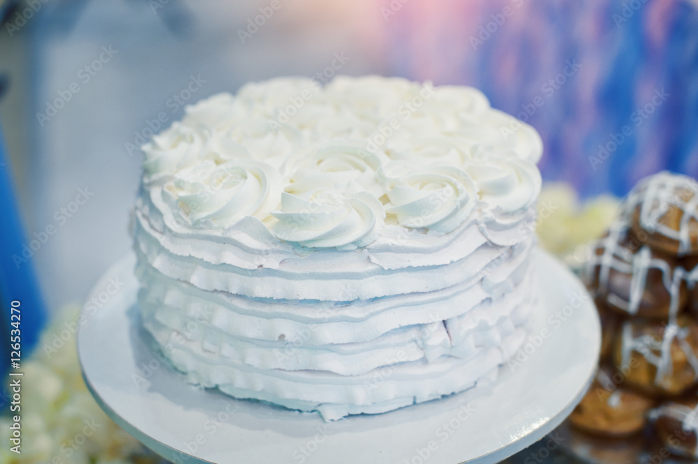 beautiful white wedding cake with flowers on a table beautiful white wedding cake with flowers on a table