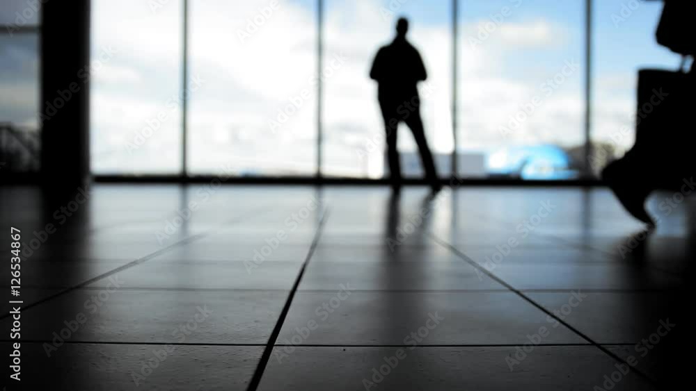 Passengers waiting to boarding in front of window in airport, silhouette