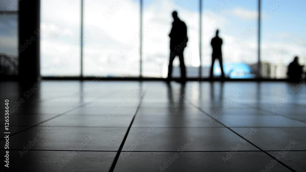 Passengers follow to boarding with baggage in front of window in airport, silhouette Passengers follow to boarding with baggage in front of window in airport, silhouette