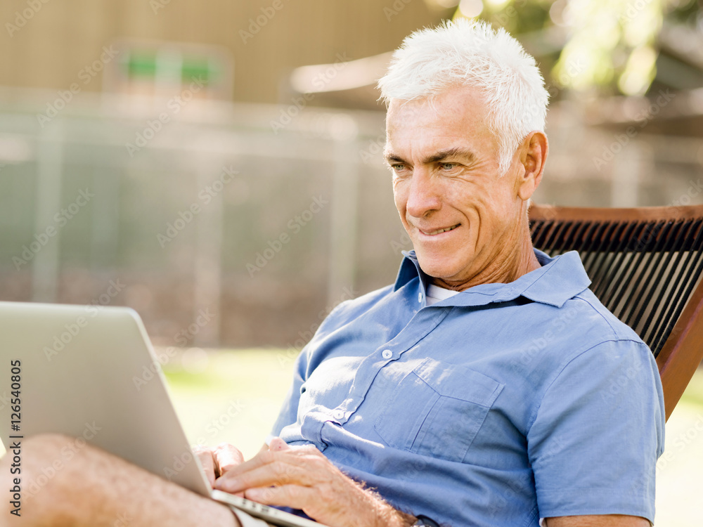Senior man with notebook sitting in the park Senior man with notebook sitting in the park
