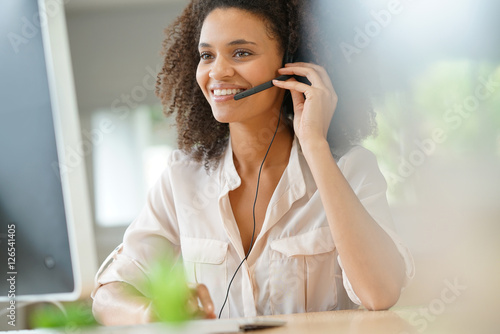 Portrait of customer service assistant talking on phone photo