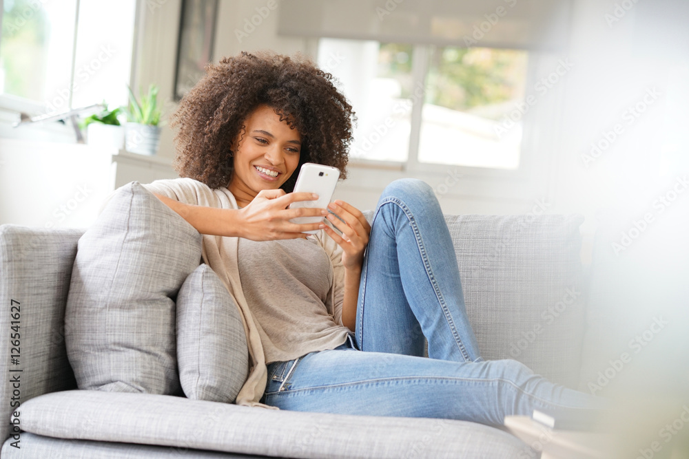 Woman relaxing in sofa and using smartphone Woman relaxing in sofa and using smartphone
