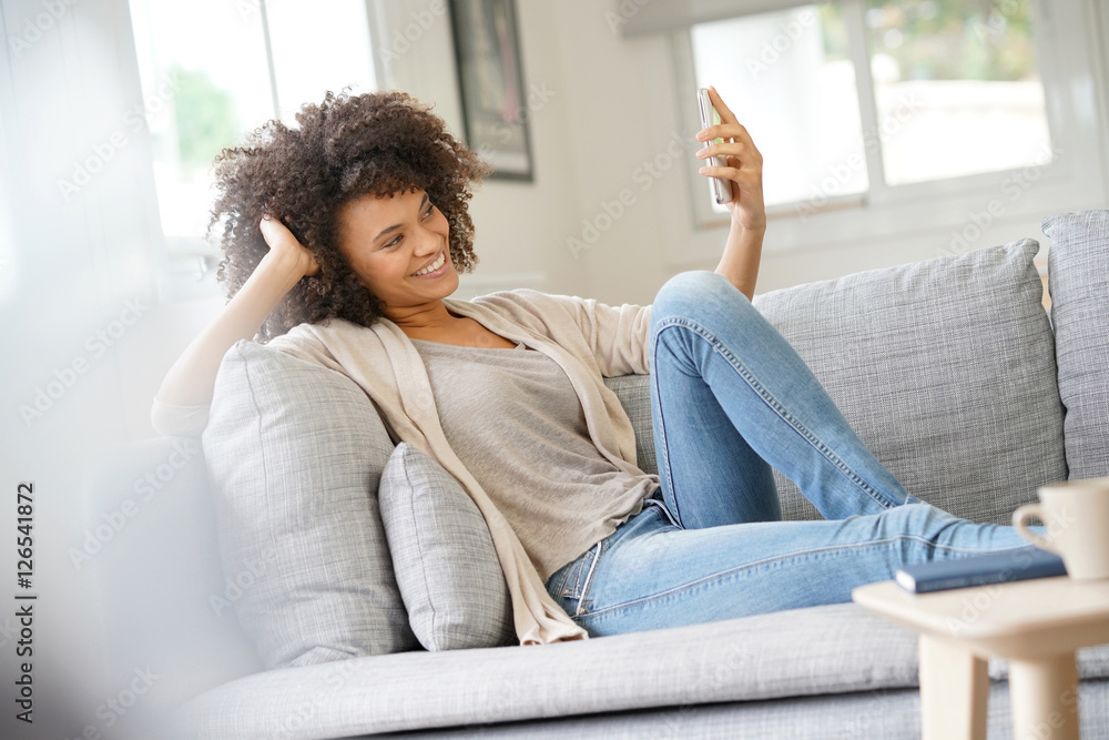 Woman relaxing in sofa and using smartphone Woman relaxing in sofa and using smartphone