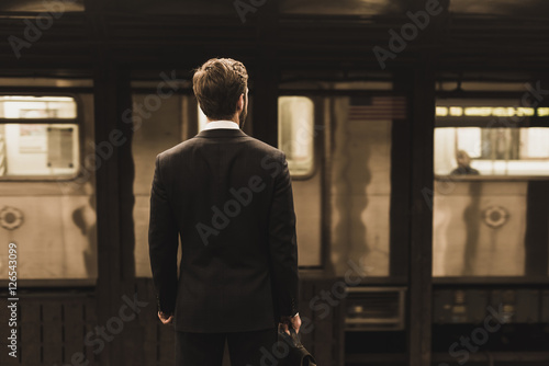 Young businessman waiting at metro station platform photo