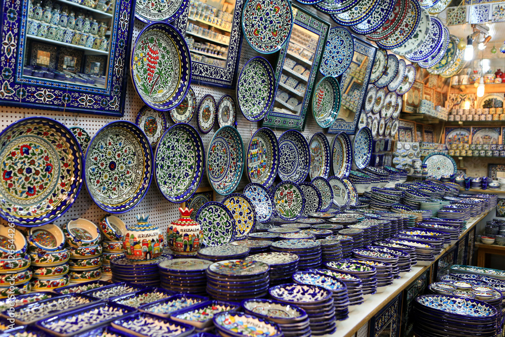 Fototapeta premium Ceramic plates and other souvenirs for sale located on Arab baazar inside the walls of the Old City of Jerusalem
