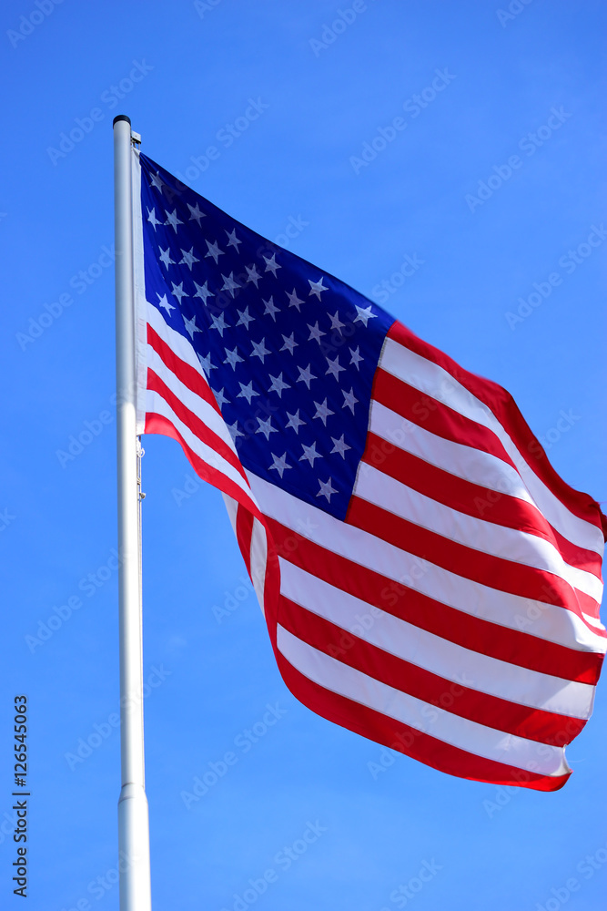 The American flag waving in blue sky
