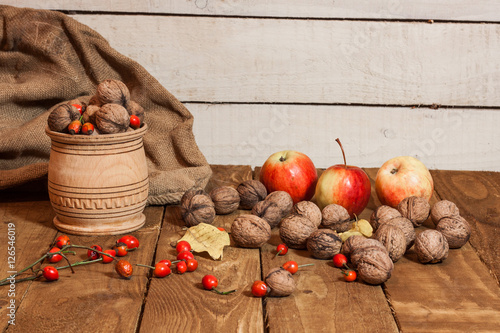 Apples and walnat in bascet,briar on old wooden board country decoration photo