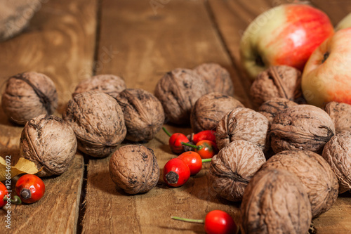 Apples and walnat,briar on old wooden board photo