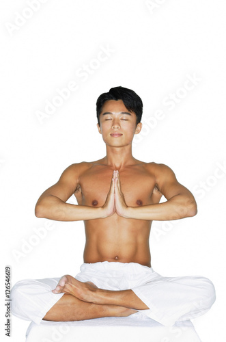 Man practicing yoga, hands together