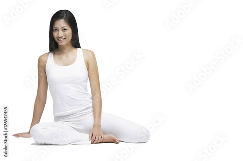 Woman sitting on floor, looking at camera, smiling