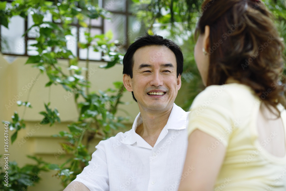 Mature couple sitting, facing each other, smiling Mature couple sitting, facing each other, smiling