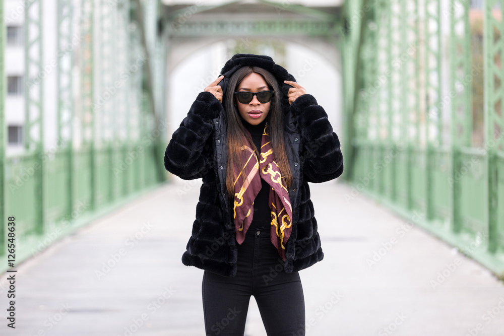 Fototapeta premium Beautiful black woman with sunglasses posing on street