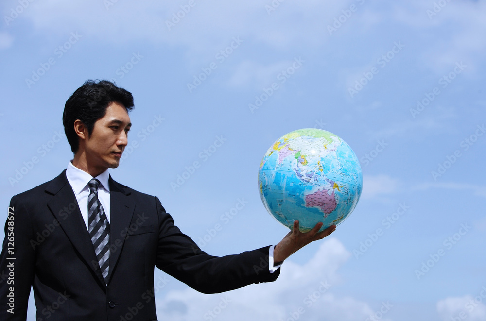 Businessman holding globe, arms outstretched Businessman holding globe, arms outstretched