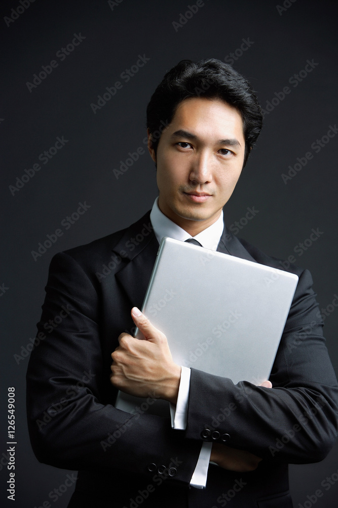 Businessman hugging laptop, looking at camera Businessman hugging laptop, looking at camera