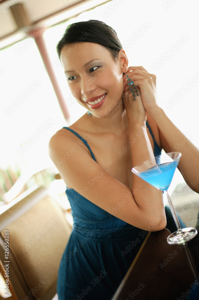 Woman sitting at bar counter, looking away, smiling Woman sitting at bar counter, looking away, smiling