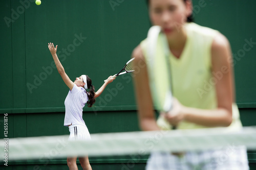 Women playing tennis together