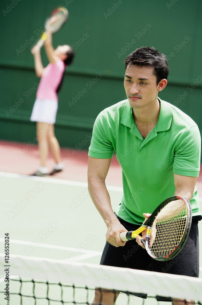 Couple playing tennis, mixed doubles