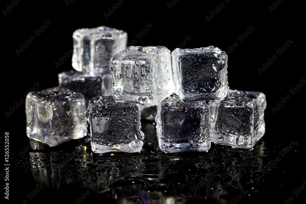 ice cubes reflection on black table background.